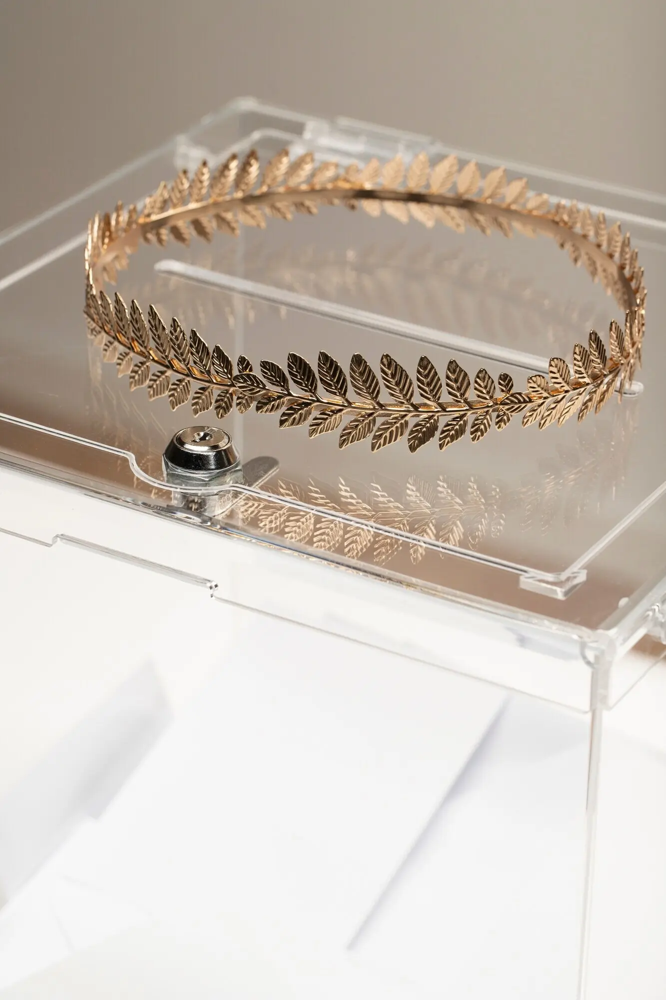 Крупный план прозрачной коробки и золотой короны.